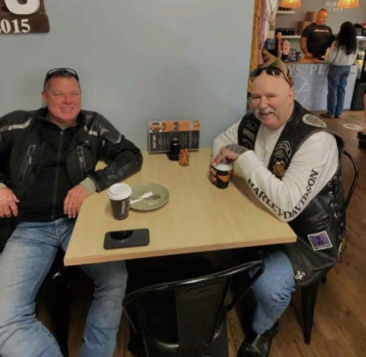 Two chapter members seated with coffee at Harry's