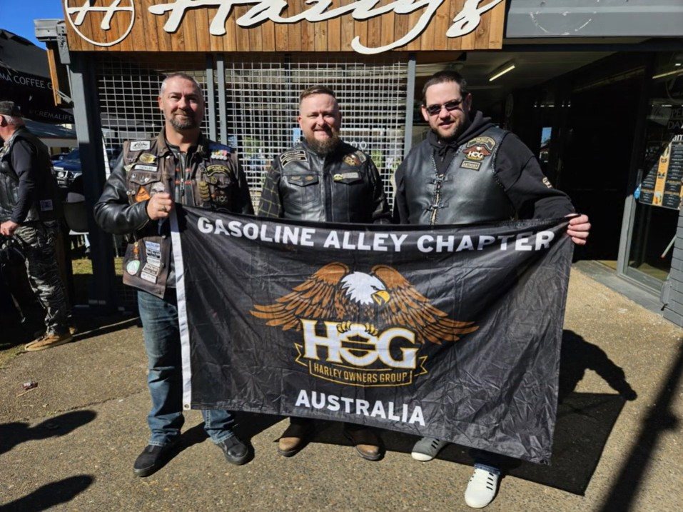 Shaneo and chapter members holding the Gasoline Alley Chapter flag