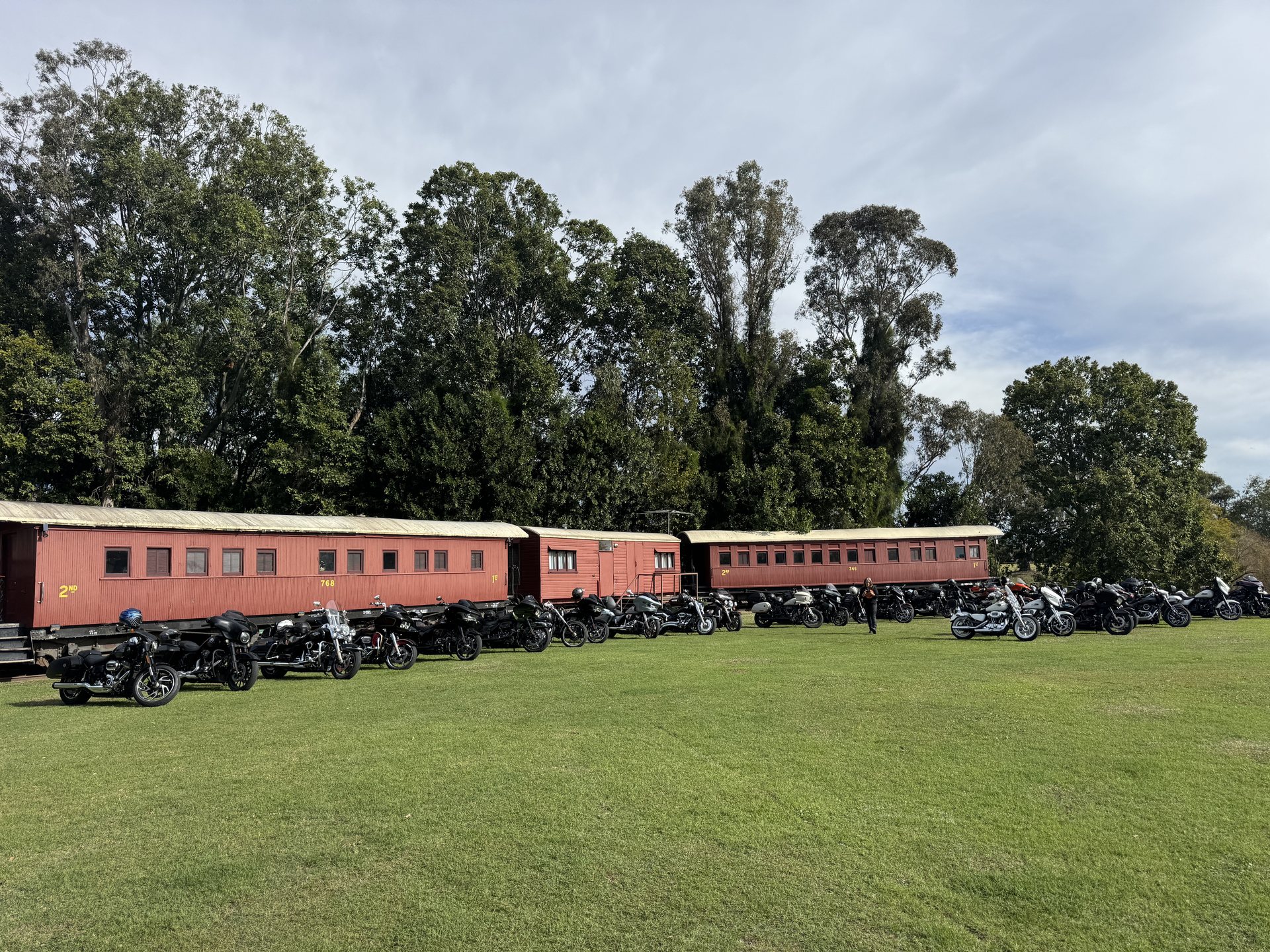Chapter motorcycles parked in front of old rail carriages at Harrisville