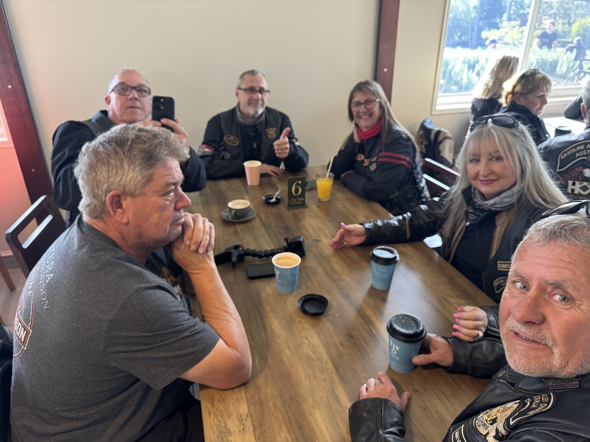 Chapter members sharing coffee around a table at Oaky Creek Farm