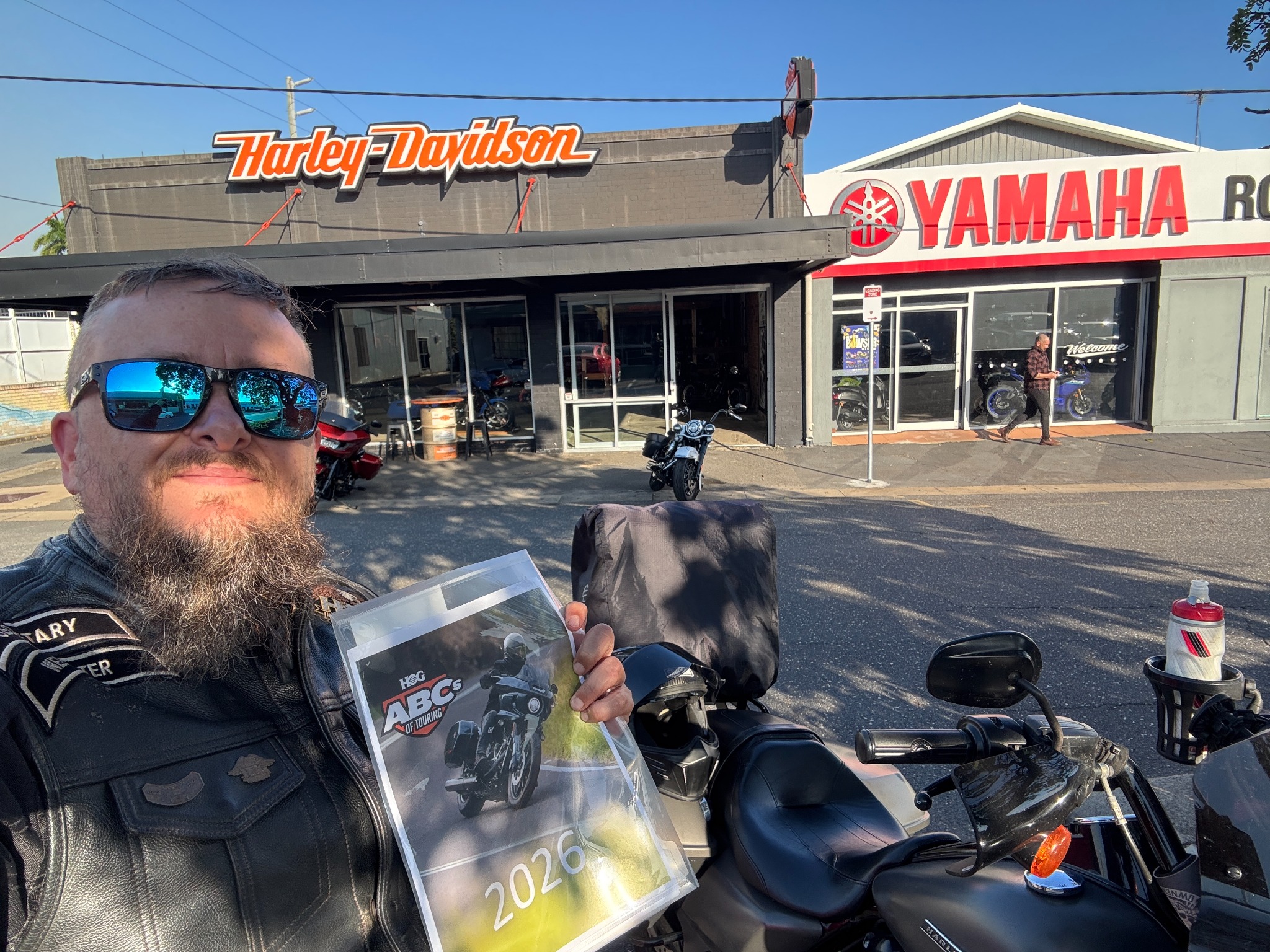 Selfie outside Rockhampton Harley-Davidson while holding the 2026 H.O.G. ABCs of Touring booklet.