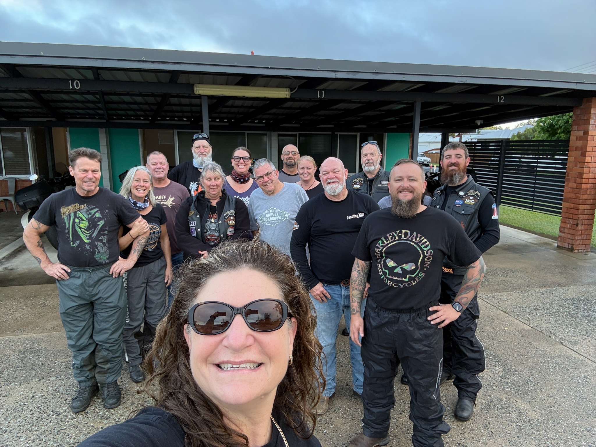 A group of rally riders posing outside their Bundaberg accommodation.