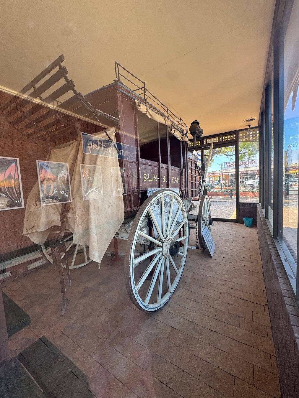 An old wagon displayed inside a heritage building.