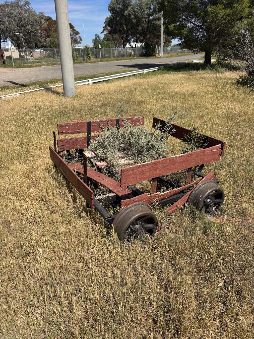 A small weathered rail trolley on display.