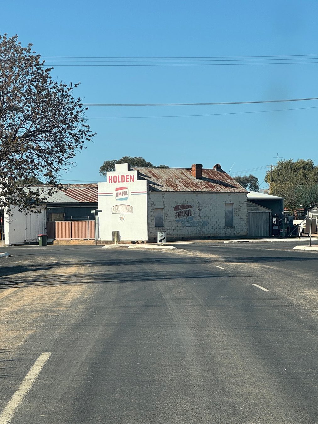 An old Holden and Ampol-painted workshop building.