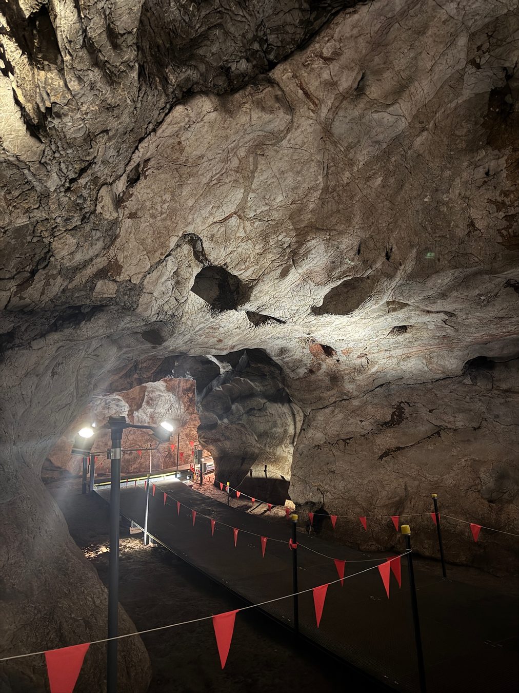 Visitors walking along a lit path inside the cave.